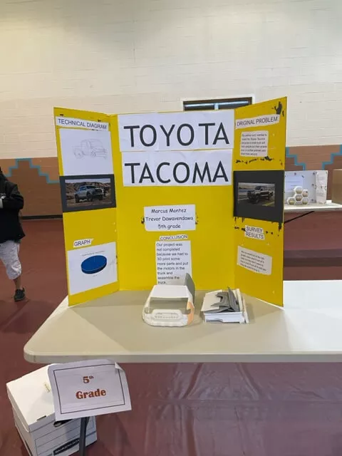 "Toyota Tacoma" Trifold Project Board and Science Project Displayed on a Table Inside the Gym at Taos Day School.