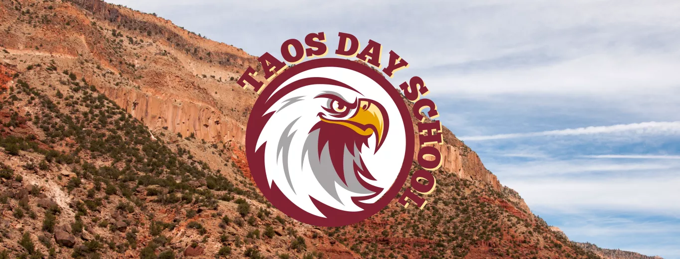 Reddish Rocky Mountains with Sage Brush and Blue Skies with White Clouds in the Background with the Taos Day School Logo Overlay.
