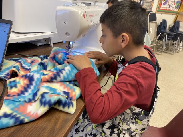 Young student using a sewing machine.