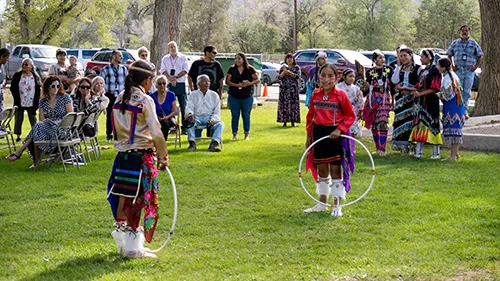 Taos Day School Students Celebrating and Wearing Indigenous Masks, Headdresses, And Traditional Regalia During a School Social and Ceremonial Occasion.