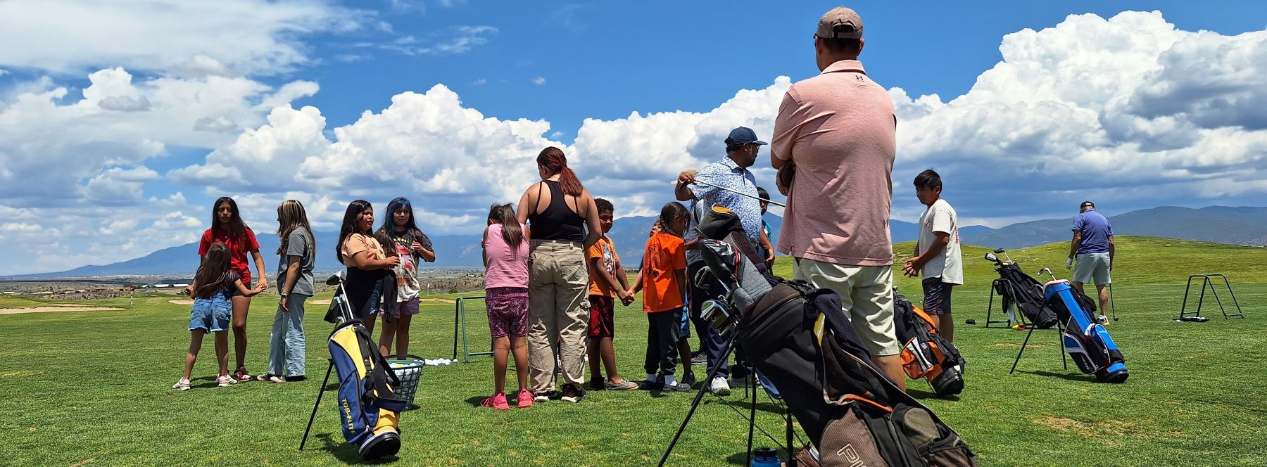 Large group of students and staff on golf course.