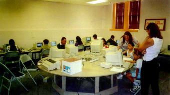 Students sitting around a table with old style computers.
