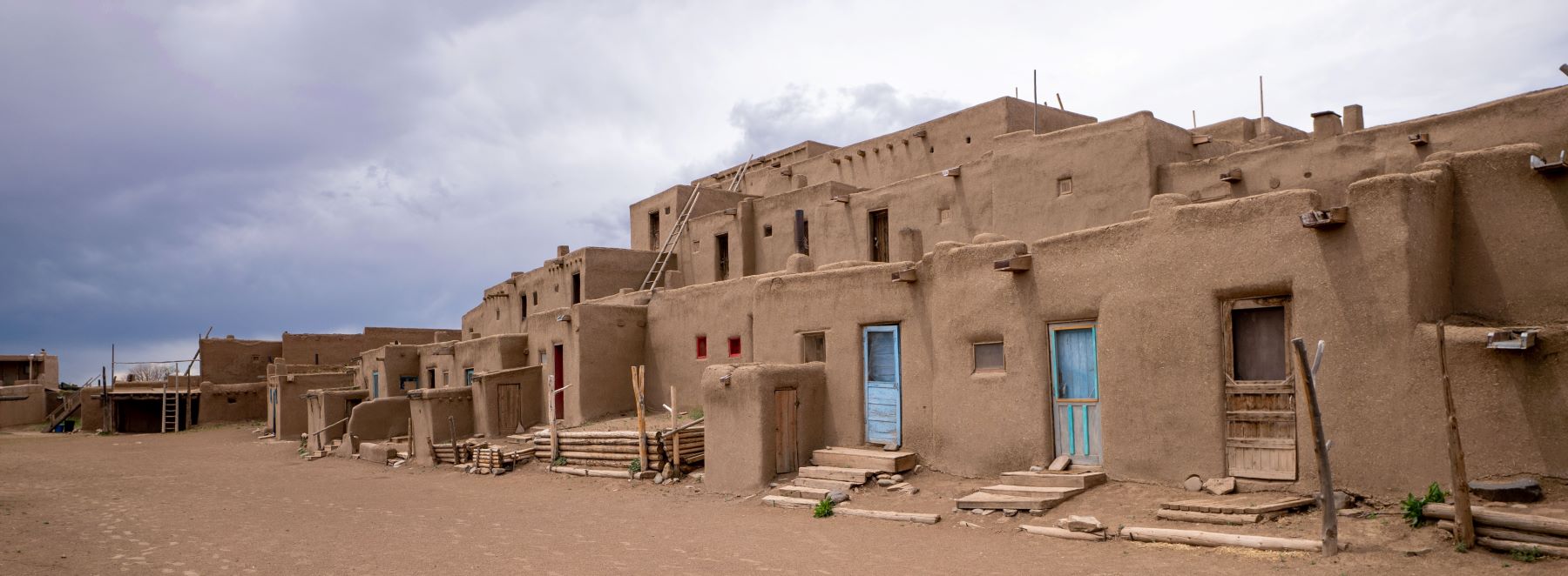A spacious adobe structure featuring vibrant blue doors, showcasing the unique architectural style.