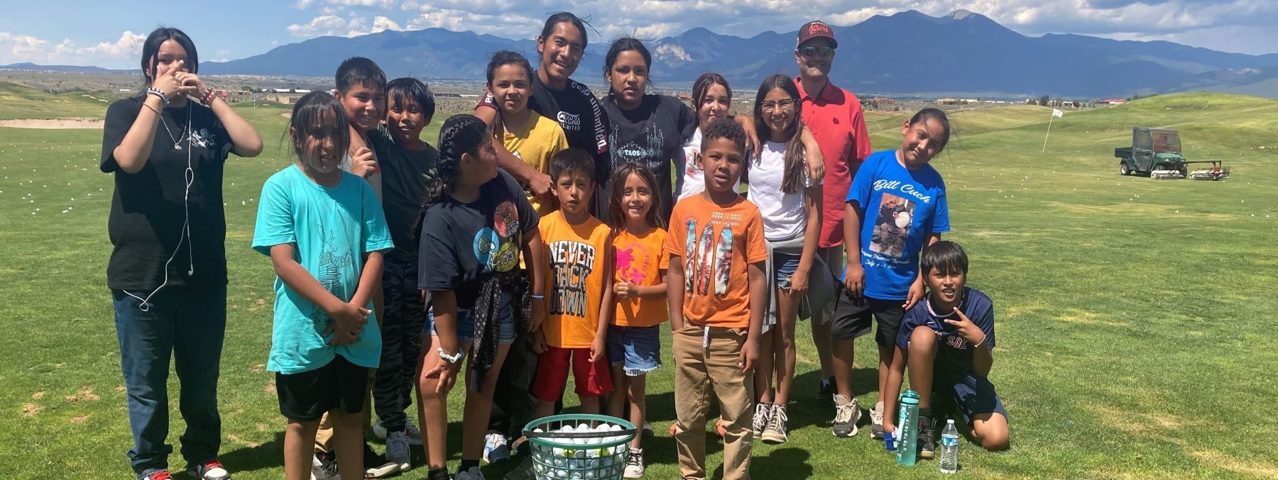 Large group of students at the golf course on a sunny day.