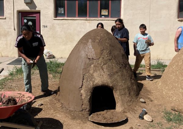 Students building horno outside.
