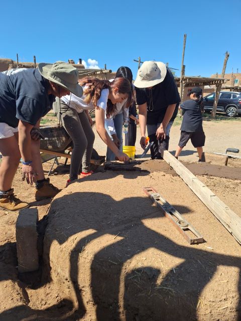 Group of students working outside with various tools.