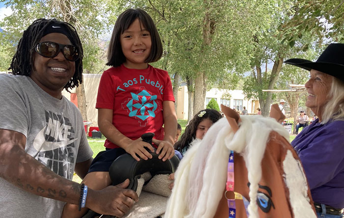 A student at Taos Day School practices horseback riding on a fake horse.