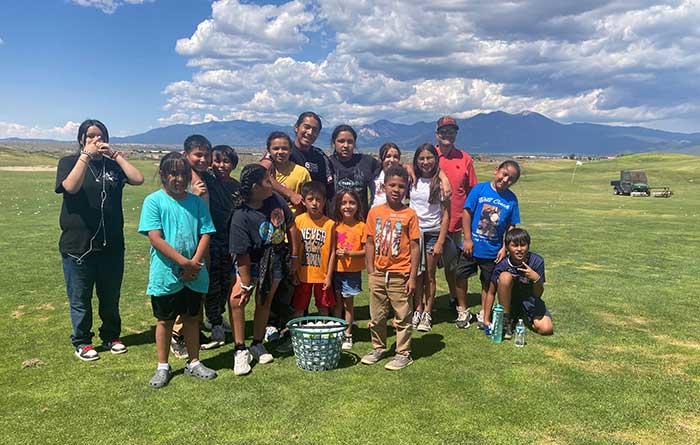 Group of students in summer program hanging out at the golf course.