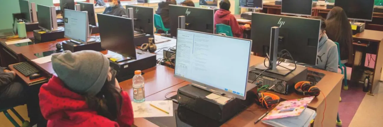 Several Boy and Girl Students Sitting as Desks with Computers in the Computer Lab at Taos Day School.