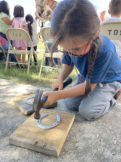 A student working on a horseshoe.